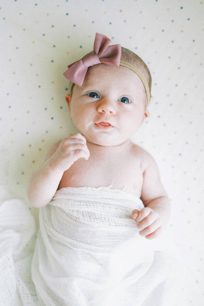 newborn baby girl looking at camera