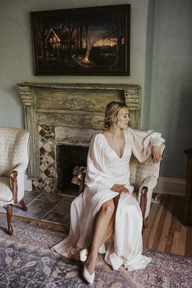 a bride sitting in a satin gown on the day of her wedding