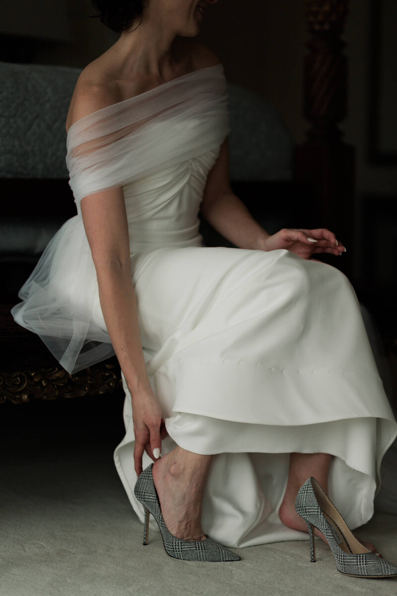 bride puts on her wedding shoes on her wedding day at The Astorian in Houston by Swish and Click Photography