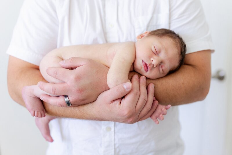 dad holds newborn son in his arms