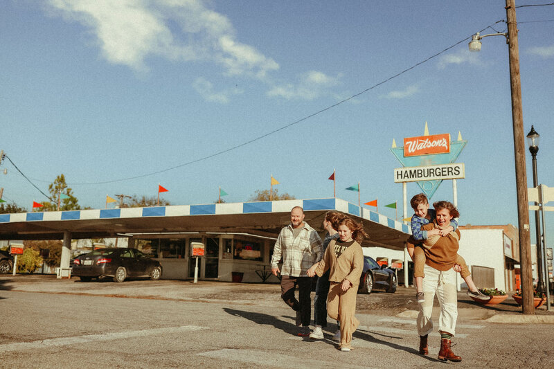 Melanie Dalton and her family walking in front of a retro burger joint. 