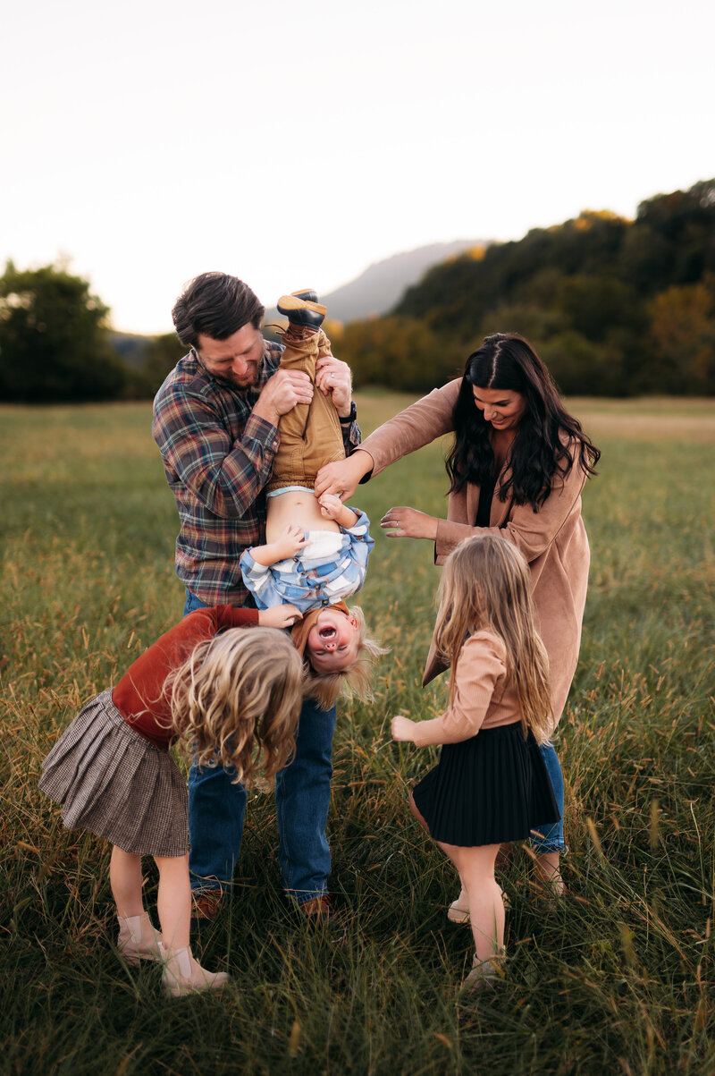 Family of five interacting with each other in an open field in chattanooga tn