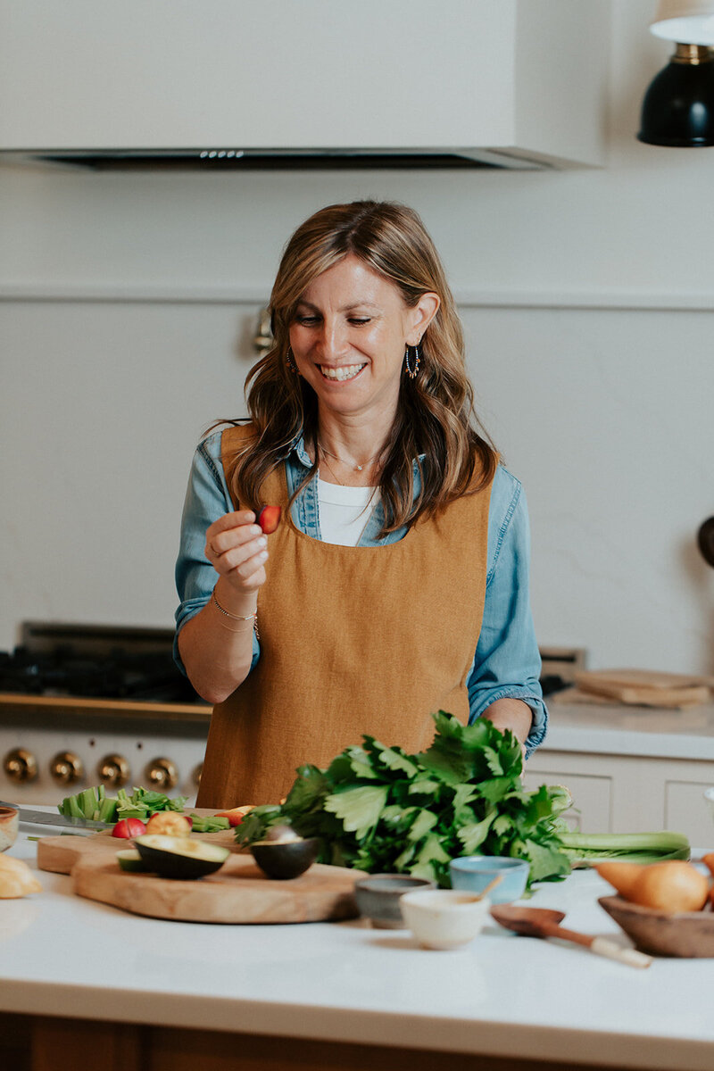 Sam smiling, chopping vegetables in her kitchen
