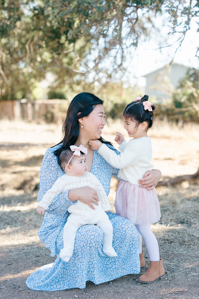 Joyful candid of a family playing together in an open field at sunset, captured during a natural light photography session in Northern California by Suzanne Karp from Little Palm Photography Studio.