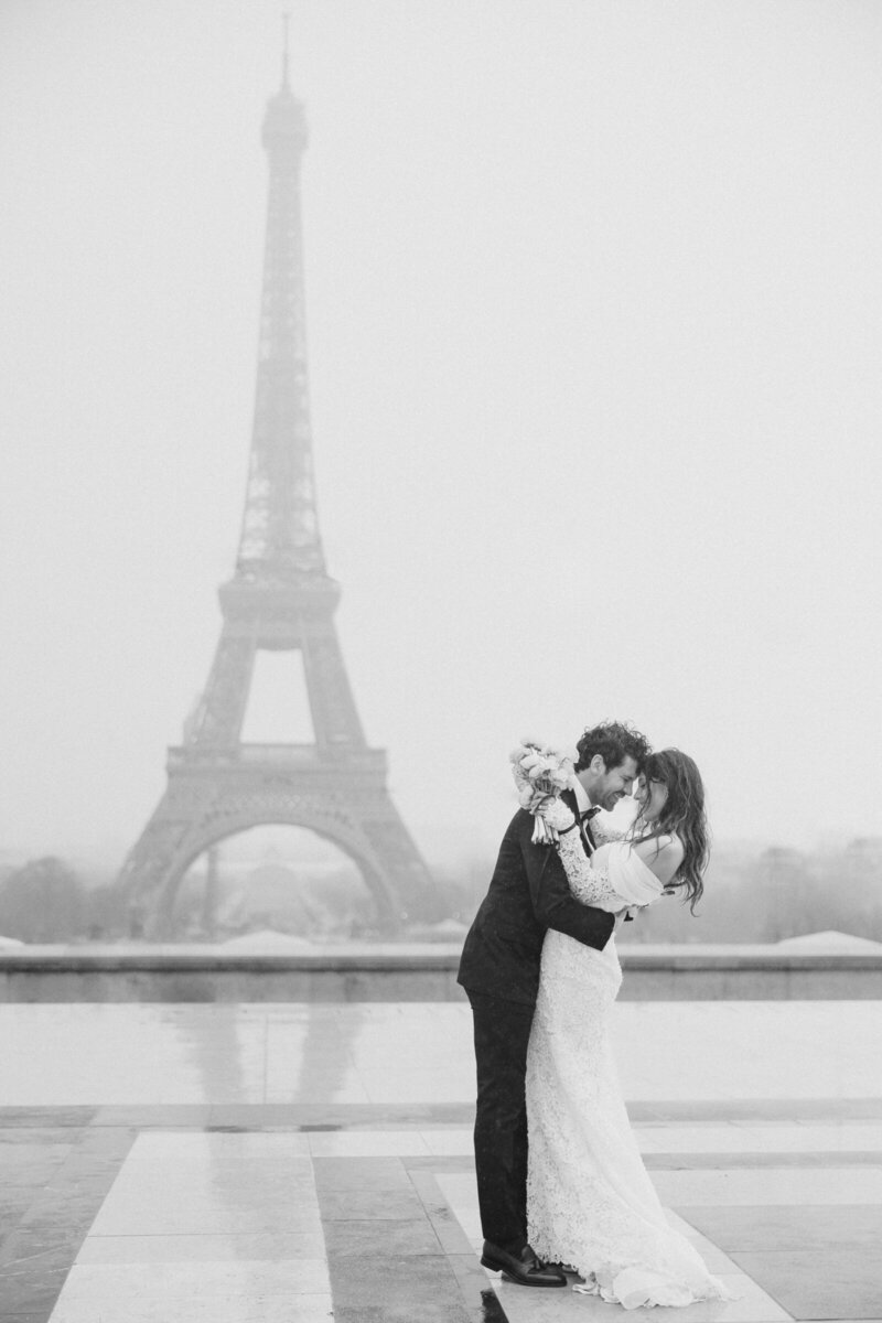 Bride and groom in front of Eiffel tower in Paris,  France, photographed by destination wedding photographer, Brittany Navin Photography