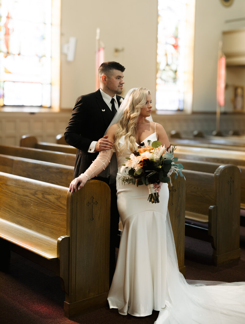 Catholic wedding bride and groom posing in pews