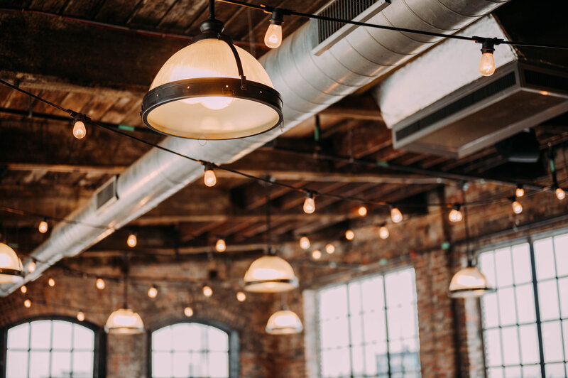 a simple photograph of cafe lights hanging form a wooden ceiling at philadelphia distilling company shot by philadelphia wedding photographer alex medvick