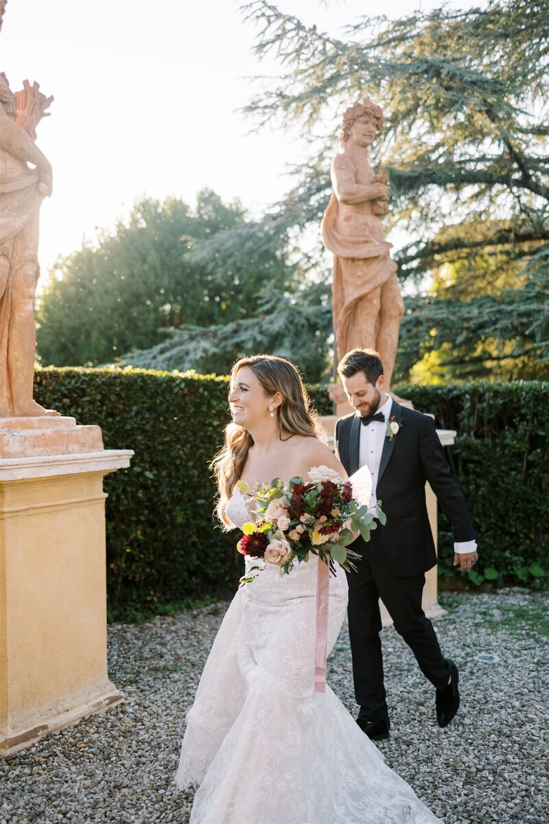 Bride and Groom walk joyfully into their outdoor reception at Villa Catignano in Siena Italy