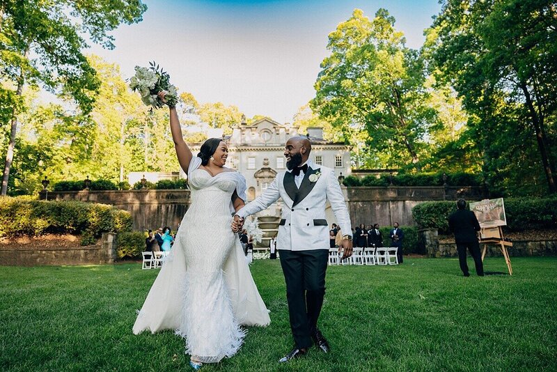 Atlanta History CeBride standing off in theCouple walkin gdown the lawn of the Swan House celebrating just after they say their I Do at the Atlanta History Museum  photographer was  REEM Photography Atlanta Wedding Planning Tinted Events Design and Planning