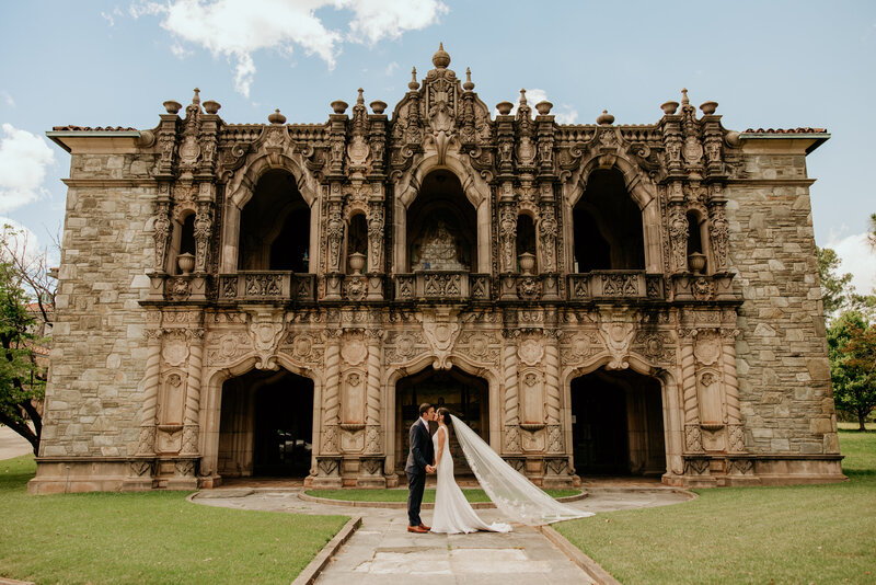 Newly married couple posing in front of a castle
