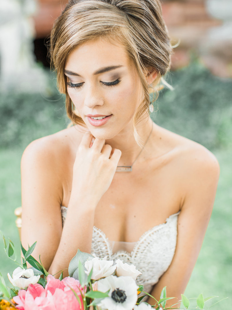 bride looks down at flowers showing off her soft, natural eyeshadow, Indianapolis Wedding Hair and Makeup