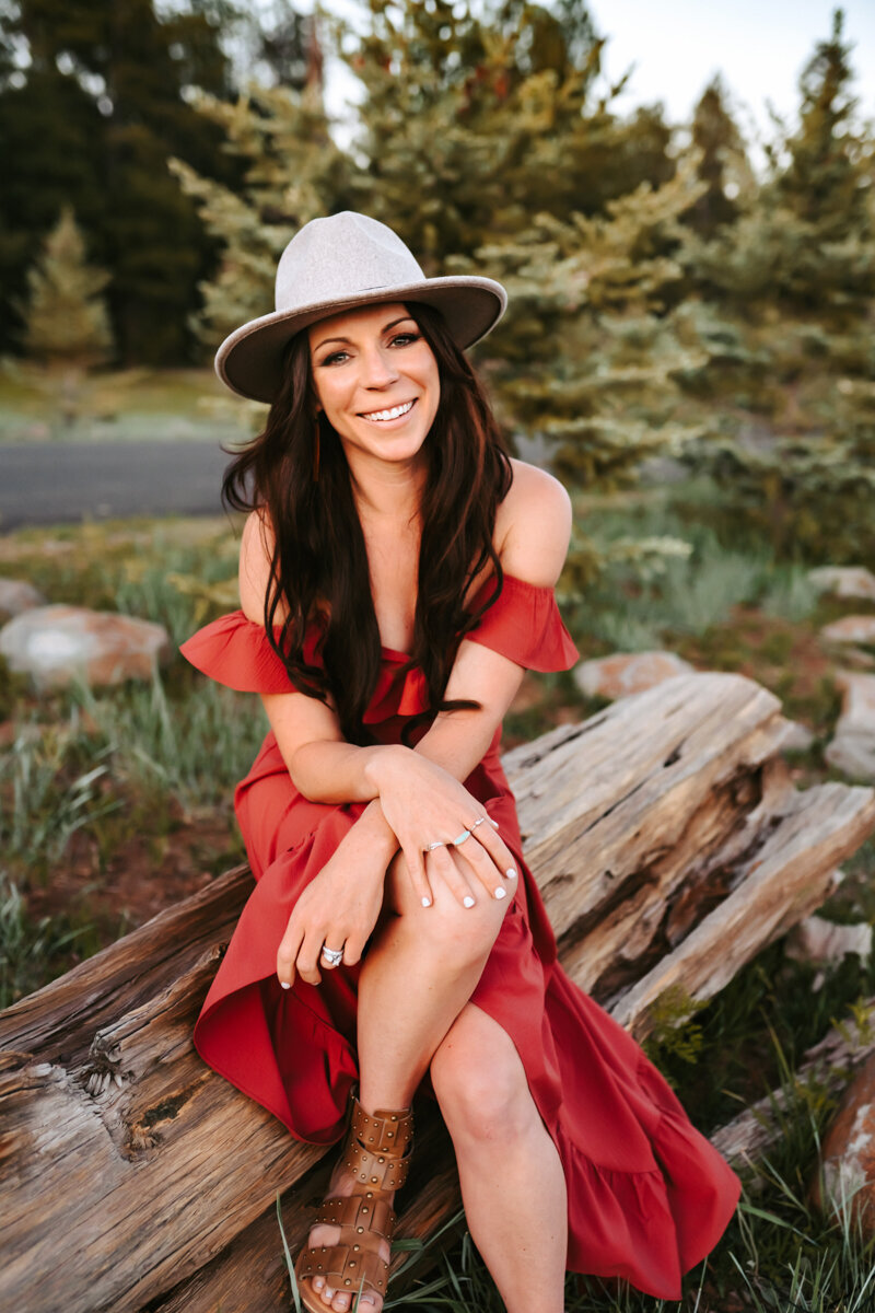 The owner of Annie Bee Photography posing in front of Lake Mary in Flagstaff at sunset.