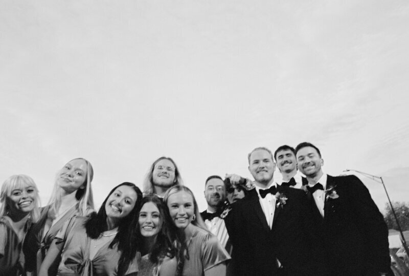 Bridal party smiling at camera by 35mm film wedding photographer Noble Photo Co