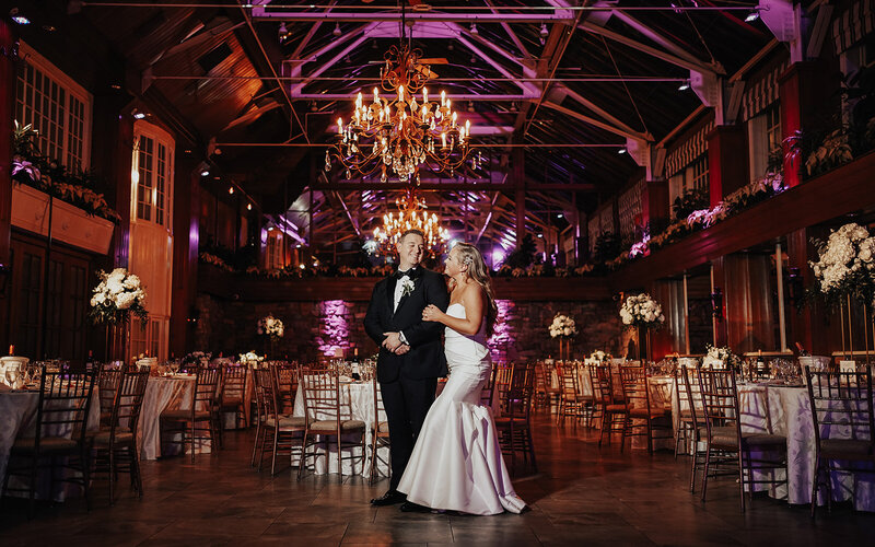 bride and groom under twinkling chandelier at indoor wedding reception