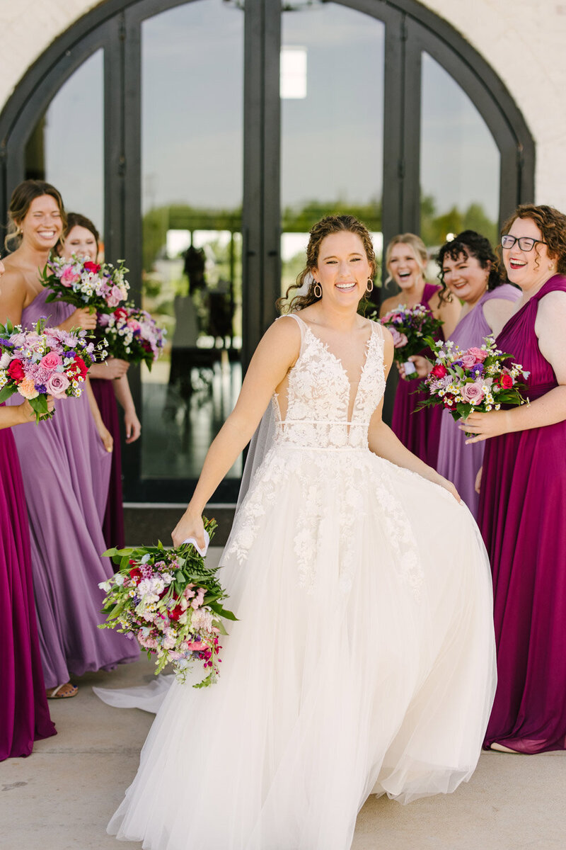 Bride surrounded by her bridesmaids holding a bouquet