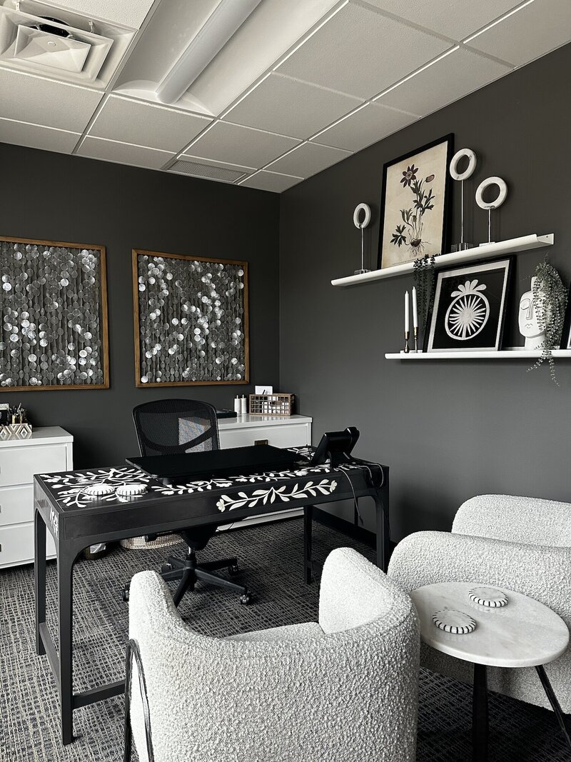 Office space with large chairs and a dark walls.