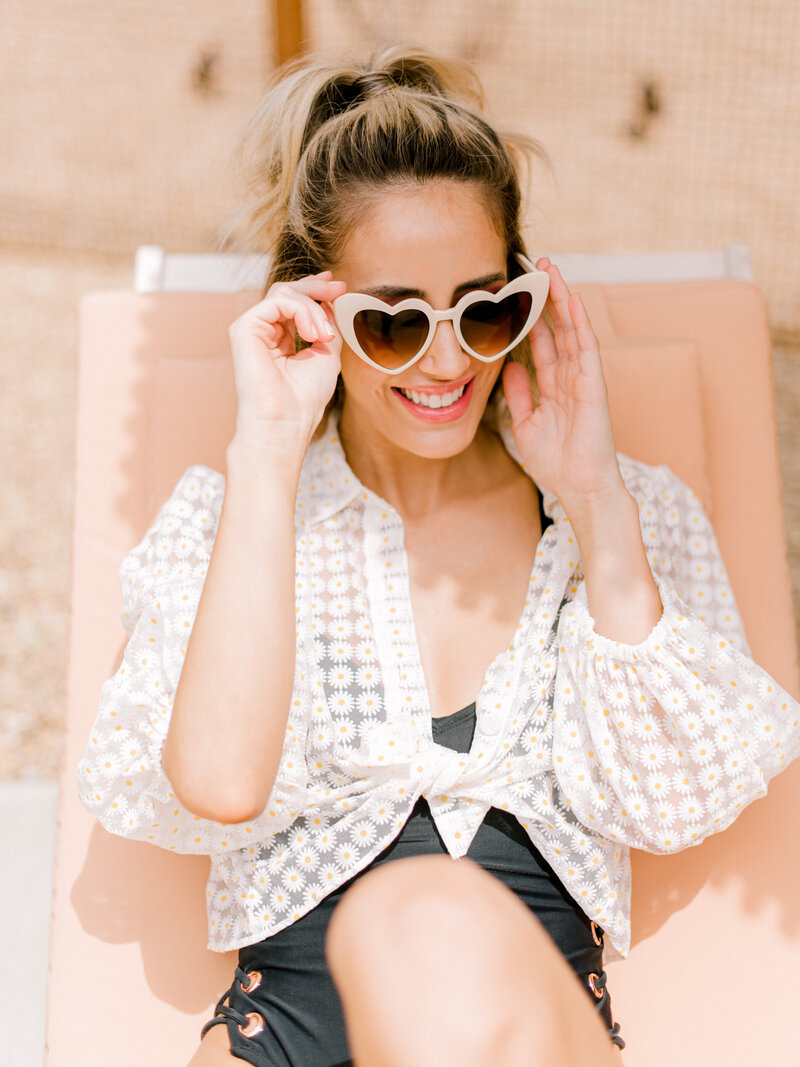 woman poolside smiling with sunglasses