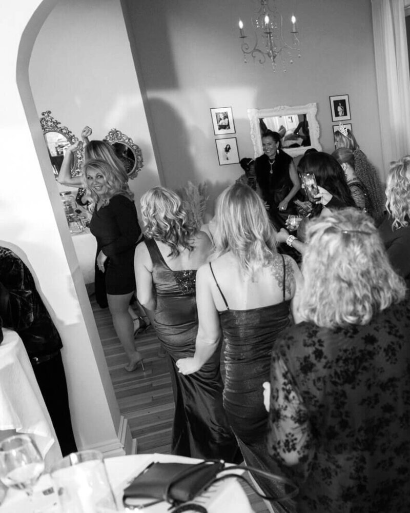 A vibrant event with guests dressed in elegant attire, mingling in a beautifully decorated venue.