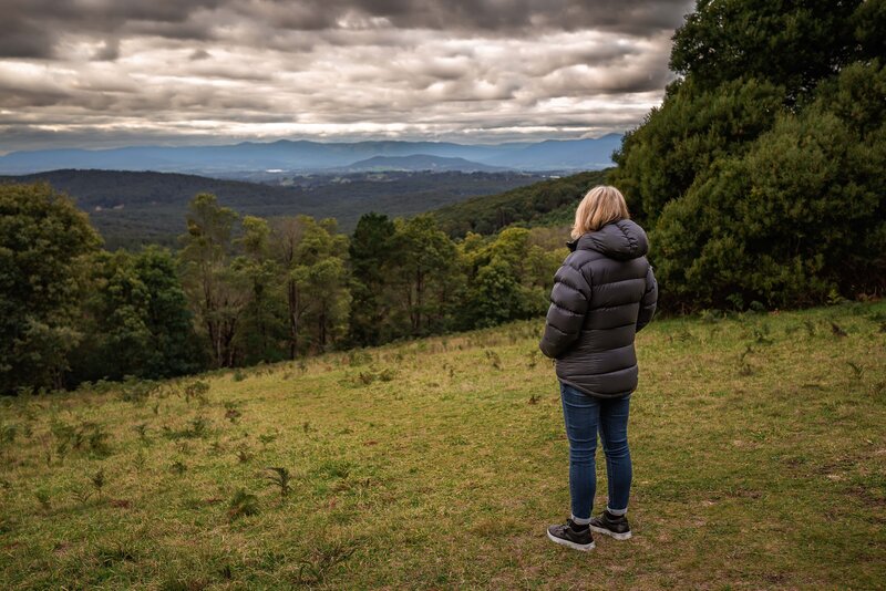 Lady ib black coat looking out over valley at Olinda