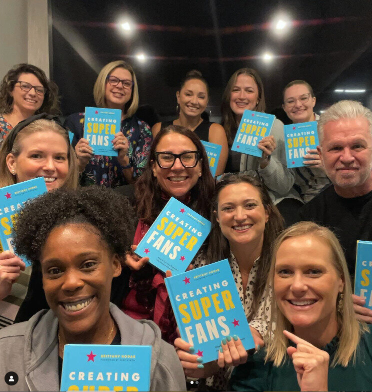 Group of readers holding their hardcover of "Creating Superfans" by Brittany Hodak.
