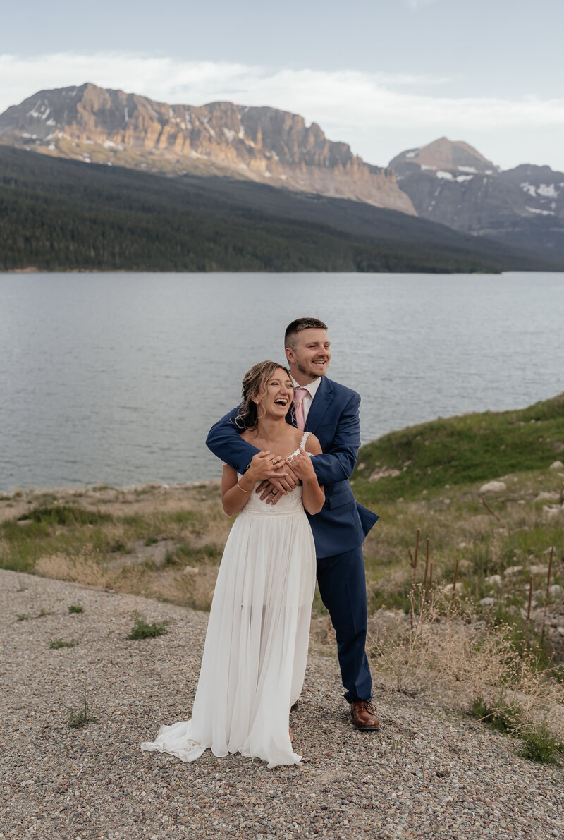 A couple embraces in front of the alpenglow in Glacier National Park.