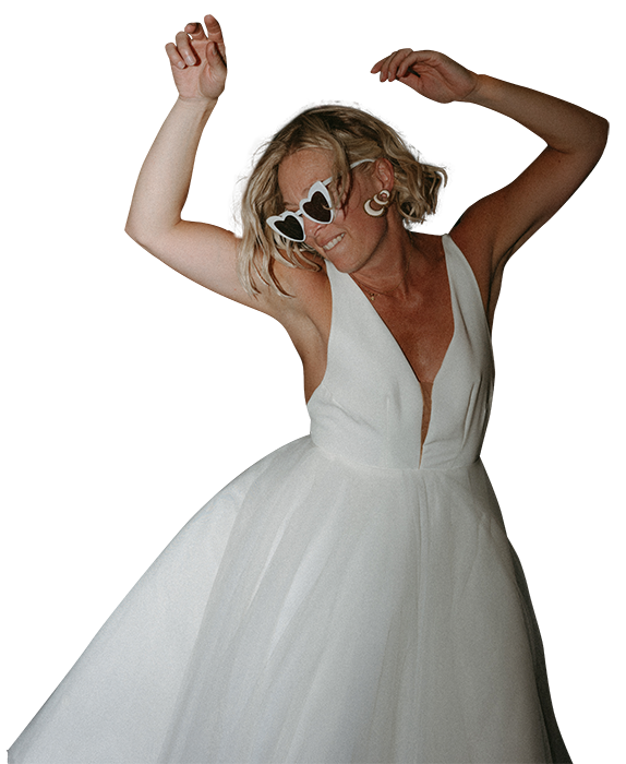 Gwladys en train de danser pendant son mariage avec des lunettes coeur vintage. Photo par kamescop, photographe et vidéaste mariage.