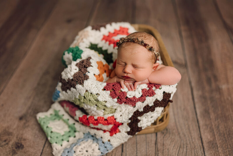 photo of newborn baby in basket with crochet blanket