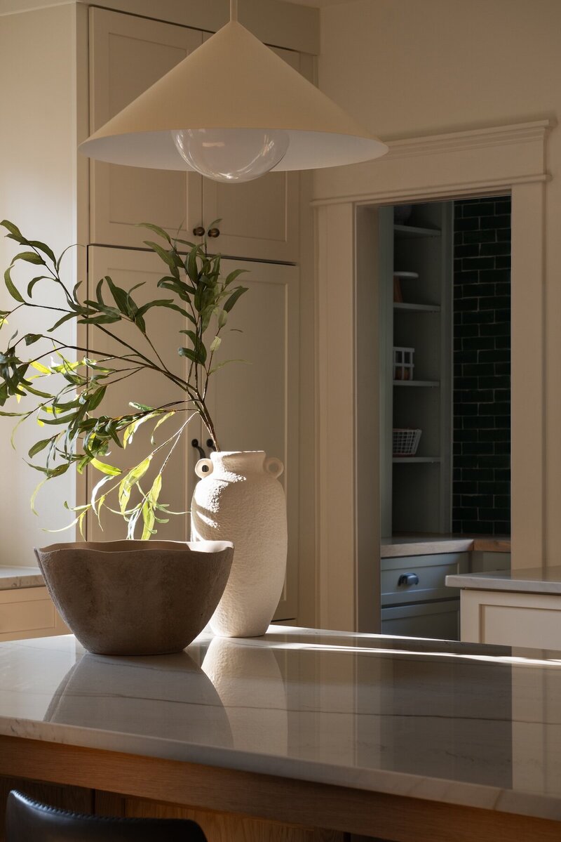  Sunlit kitchen with rays streaming in, showcasing built-in pantry drawers and shelving for organized storage.