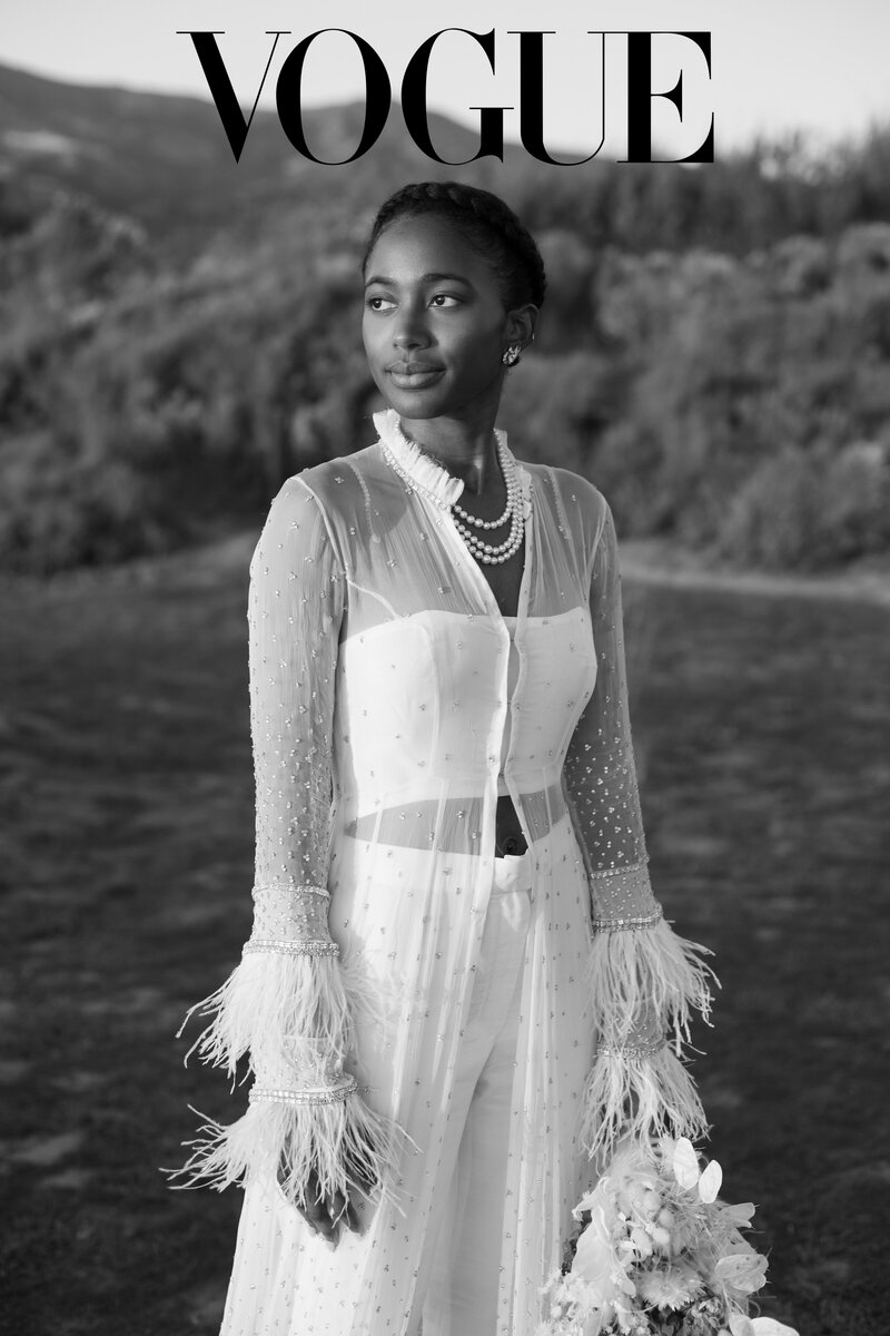 Stylish African American bride wearing a modern white bridal pantsuit, featured in Vogue Magazine, redefining wedding fashion with confidence.
 photographer Mo Davis