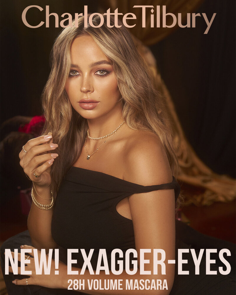 Charlotte Tilbury Exagger-Eyes 28H Volume Mascara campaign featuring Adison Justis, posing with soft waves and radiant makeup in an elegant setting.