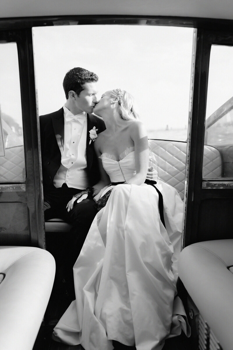Bride and groom kissing on a boat after their Venice wedding