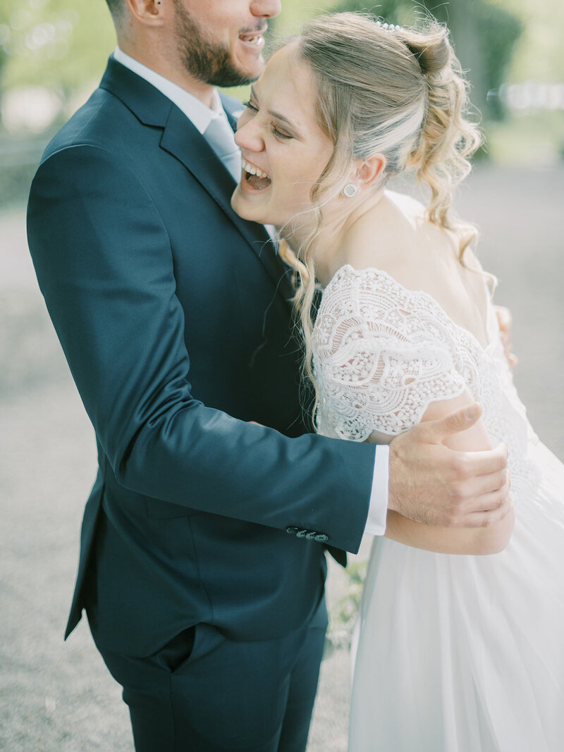 A-bride-and-groom-hugging-in-a-park