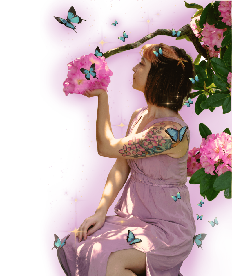 Women in pink greek styled gown holding up pink flowers with left hand as she looks at them blue butterflies are all around her and golden light eminates from woman and butterflies