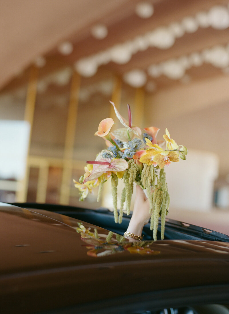 Bridal bouquet resting on car hood outside Marin Civic Center.