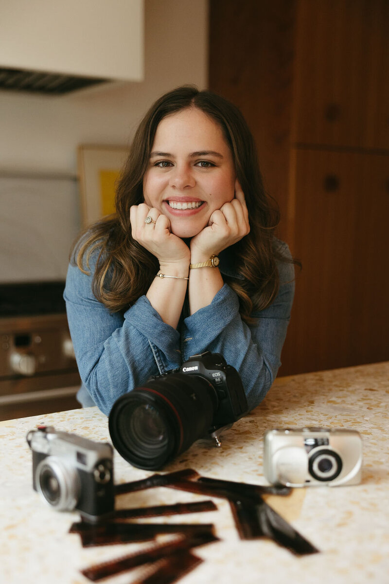 Photographer sits with cameras on table