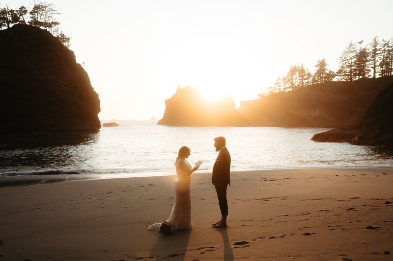 Elopement ceremony at sunset with seastacks lit by golden light in the background, a great elopement idea.