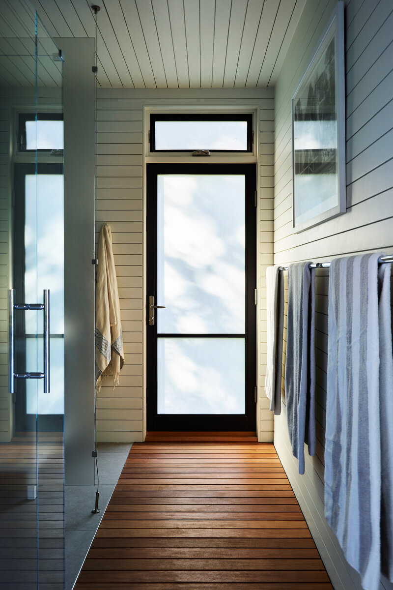 Boston interior designer Sarah Scales creates a sleek, modern bathroom in a newly constructed Hingham pool house, combining elegance with functional design.