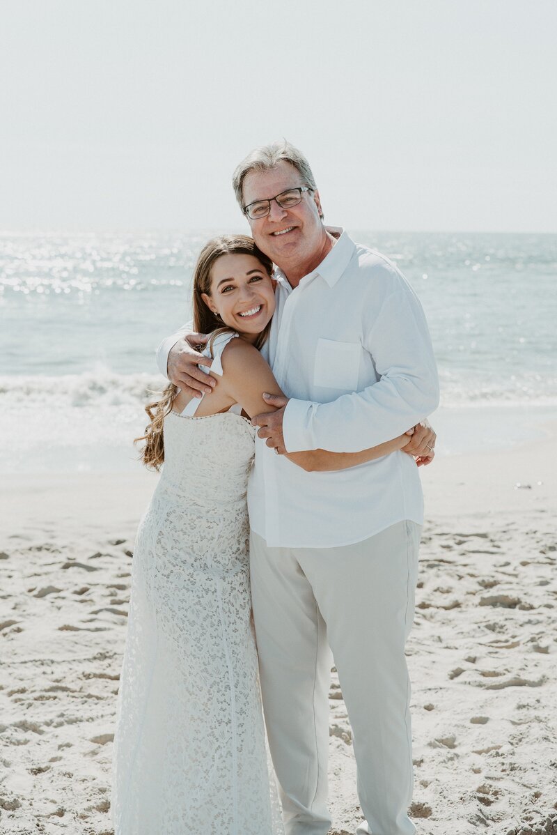 father and bride hugging on beach at Los Angeles wedding