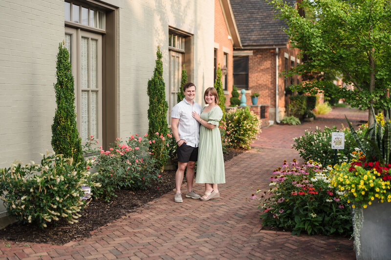 A couple hugs each other and smiles during their German Village engagement session