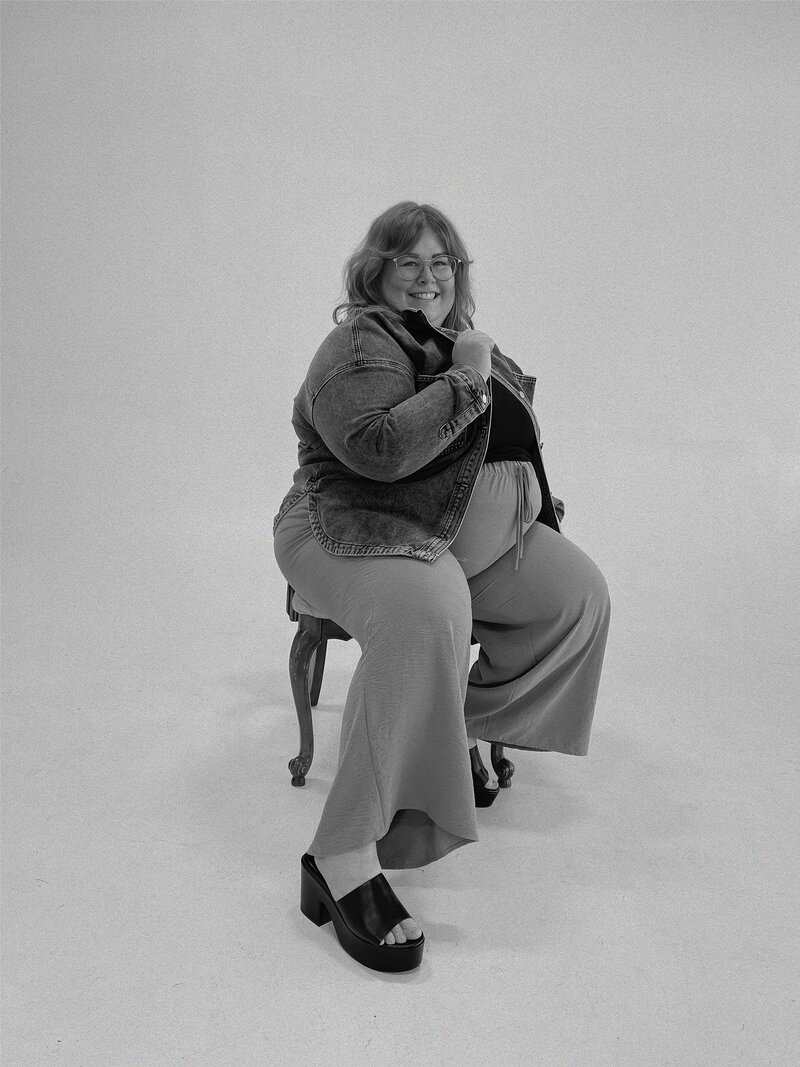Web designer annie b. smiling at the camera while sitting in a chair