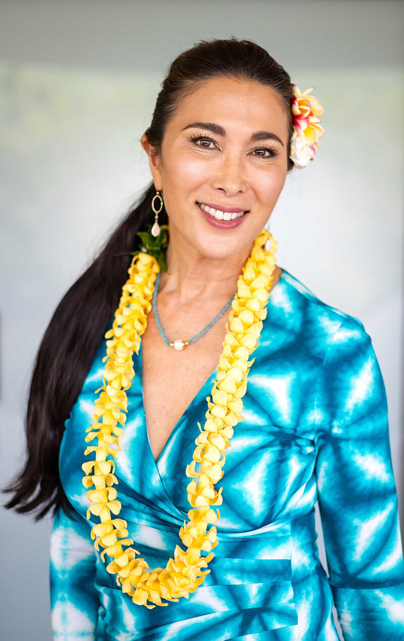 dermatology office woman in blue dress and lei smiling