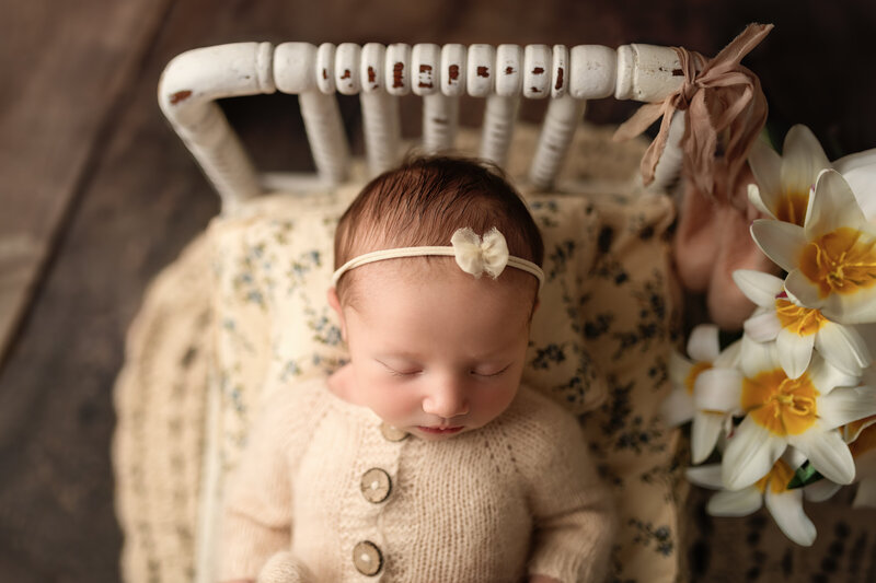 Newborn photographed on a rustic vintage spindle bed with daffodils in Paris, Ontario. A spring-inspired heirloom portrait.