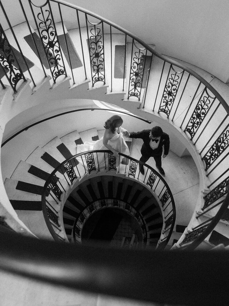 Bride and groom walking down a a spiral staircase