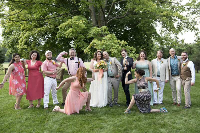 Wedding guests flexing and laughing with a newlywed couple 