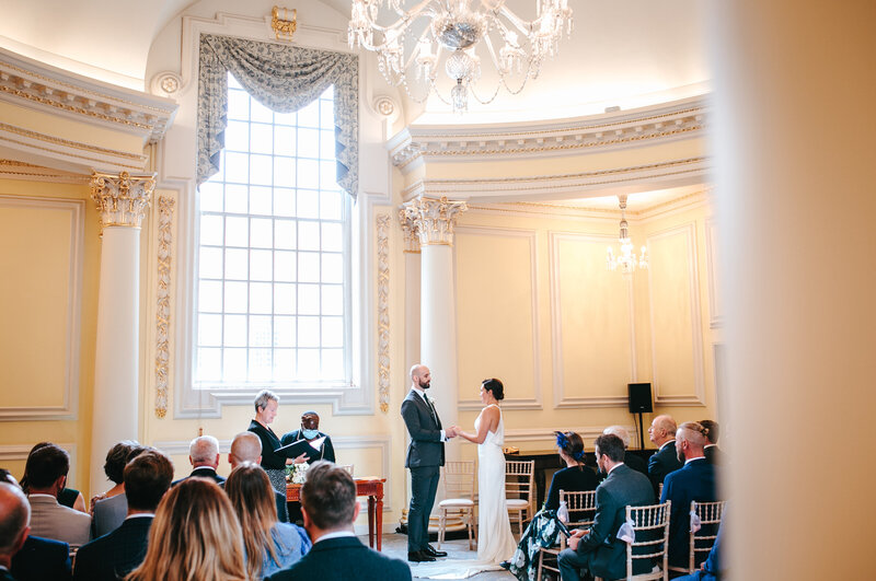 Witness the beautiful and heartfelt exchange of vows in this candid picture captured in the enchanting surroundings of Bloomsbury. This image encapsulates the genuine emotions and deep commitment shared between the couple, creating a truly unforgettable and meaningful moment.