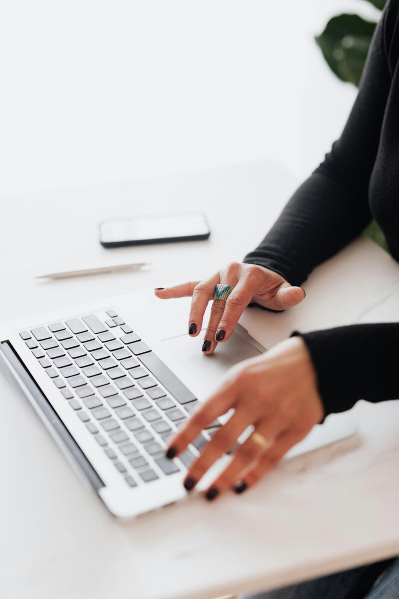 Woman’s hand with black nail polish working on a laptop keyboard, symbolizing customized financial solutions. Ataraxis Financial provides tailored financial strategies and bookkeeping services to give business owners the peace of mind they deserve, knowing their finances are in expert hands.