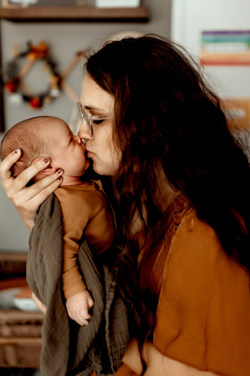 Justine Michelle kissing her 6th baby during a newborn photography session.