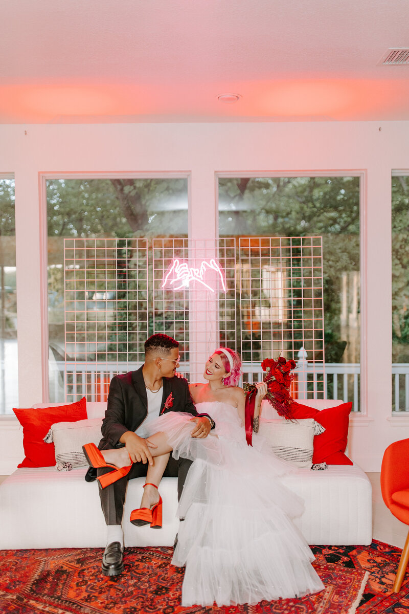 bride with red shoes sitting in groom's lap