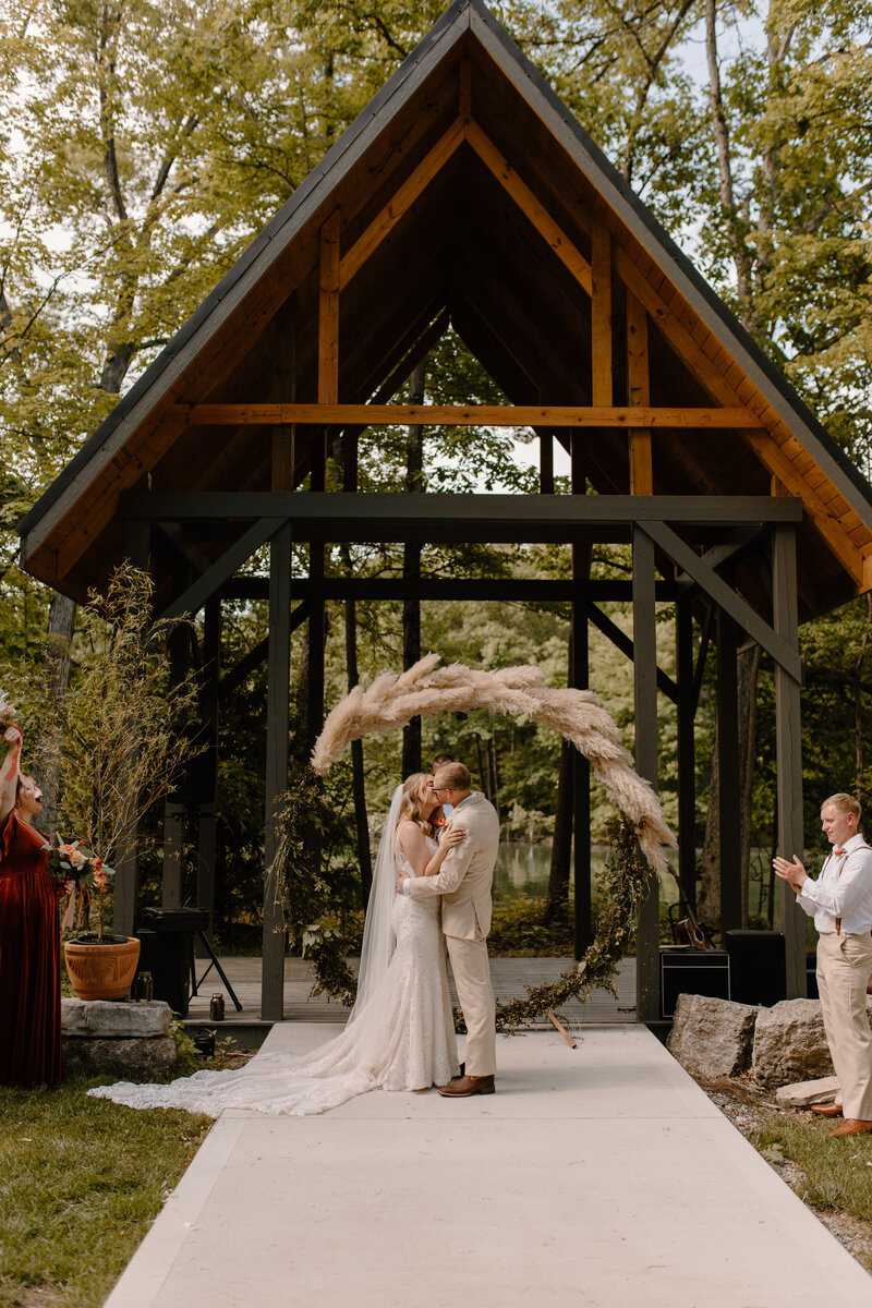 bride and groom kissing at alter