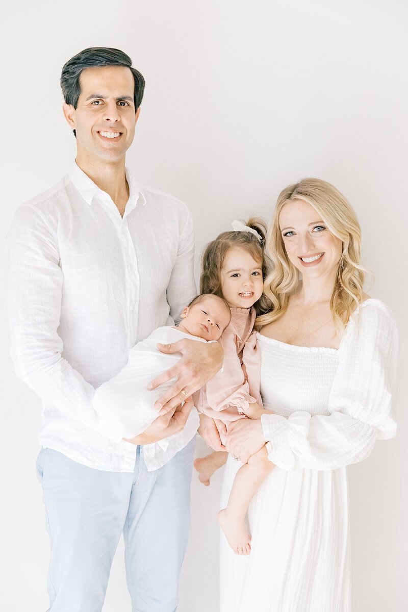Family standing and smiling during newborn session by charlotte nc